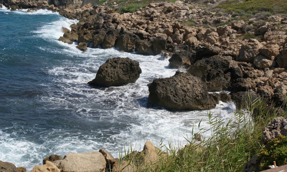 a rocky beach with a body of water