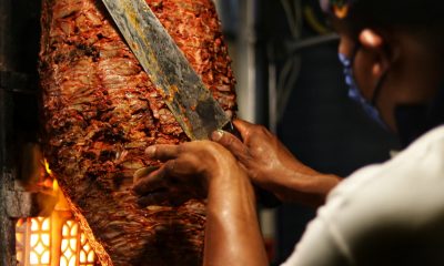 person holding sliced meat during daytime