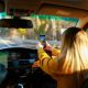a woman driving a car with a cell phone in her hand